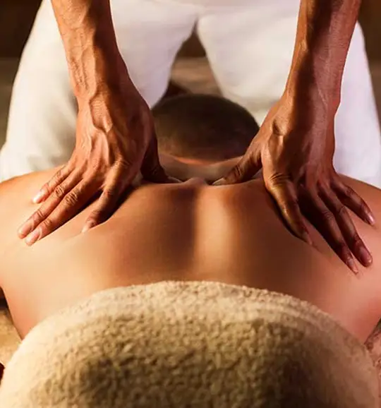 Spa therapist performing deep tissue back massage